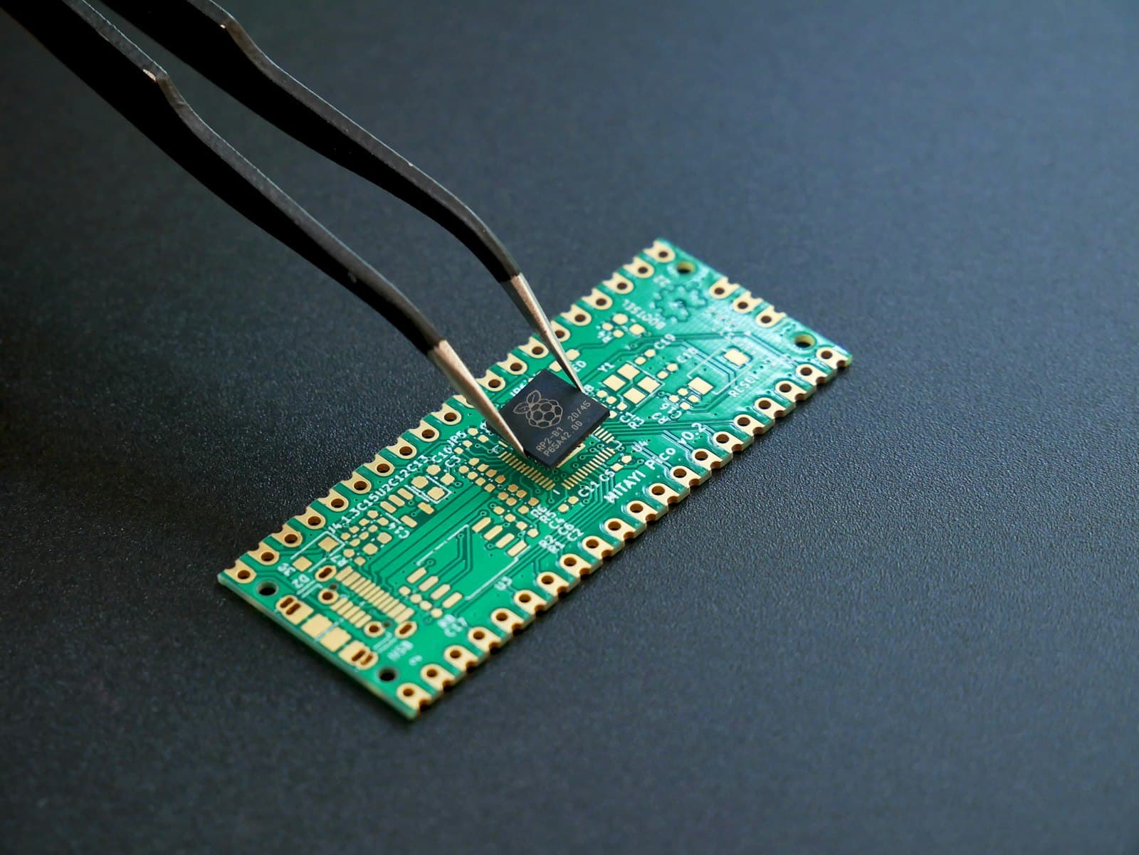 Tweezers placing a microchip onto a circuit board